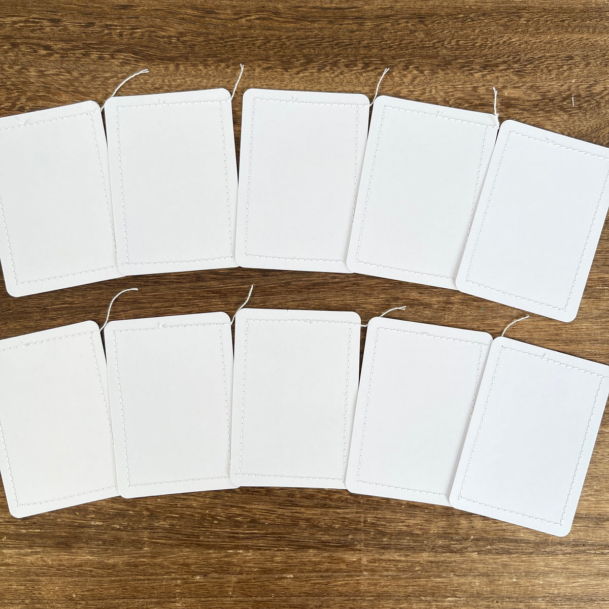 Ten white cards with thread